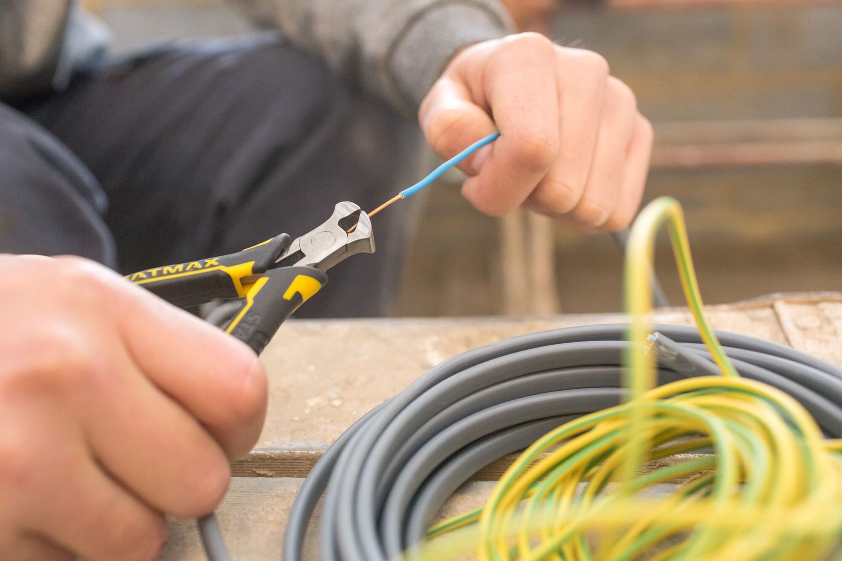 Stanley FMHT0-80519 pinza diagonal corta cable azul, cables enrollados en mesa, fotografía de primer plano.